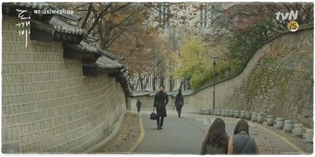 Kim Shin sedang berjalan di samping istana Deoksugung