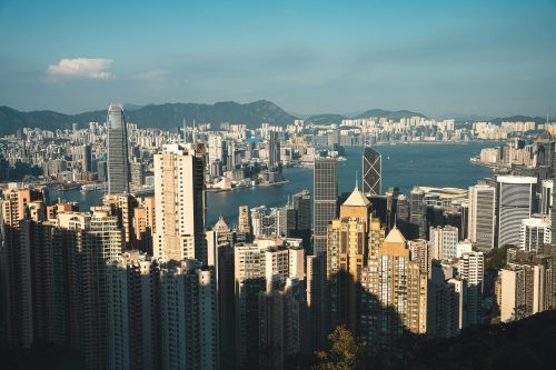 Ilustrasi Pemandangan gedung pencakar langit di Hong Kong yang mencerminkan budaya kerja kompetitif dan cepat