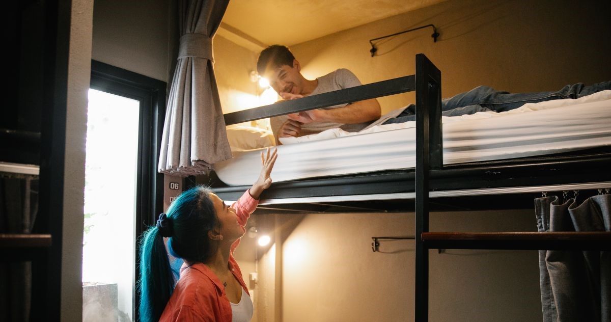 Tips memilih penginapan murah: Ilustrasi kamar hostel dormitory bergaya minimalis dan estetik untuk backpacker
