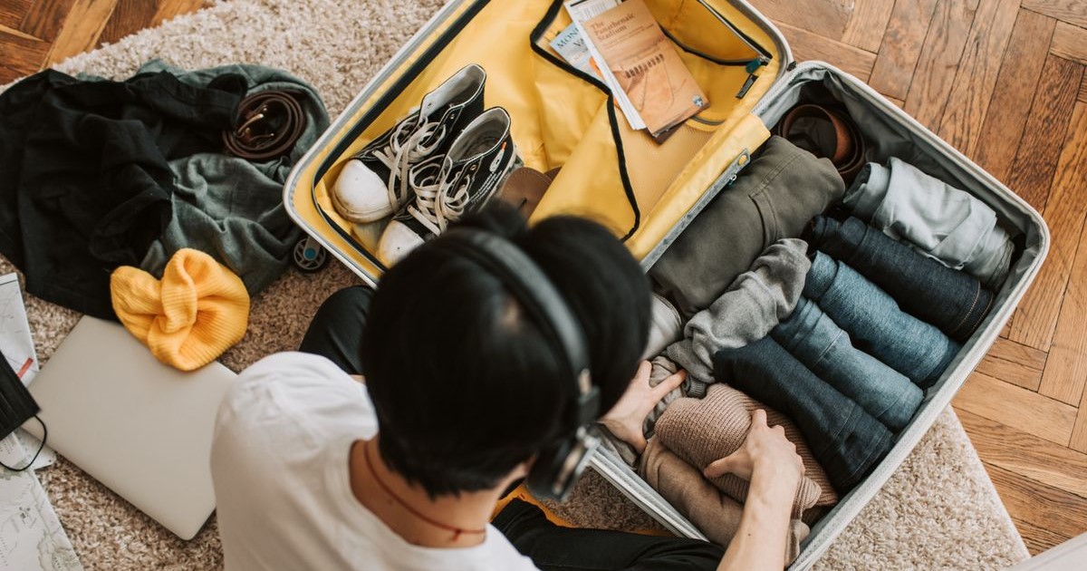 Tips packing hemat: Ilustrasi menyusun pakaian dengan metode gulung ke dalam koper ransel