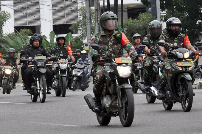Sejumlah personel Polri bersama prajurit TNI melakukan patroli pengamanan bersama melintasi Jalan Balaikota Medan, Sumatera Utara, Sabtu (19/10/2019). Menjelang pelantikan Presiden dan Wakil Presiden, jajaran Polda Sumut dan Kodam I Bukit Barisan menggelar patroli keamanan bersama menggunakan sepeda motor mengelilingi sejumlah kawasan di Kota Medan. ANTARA FOTO/Septianda Perdana/foc.