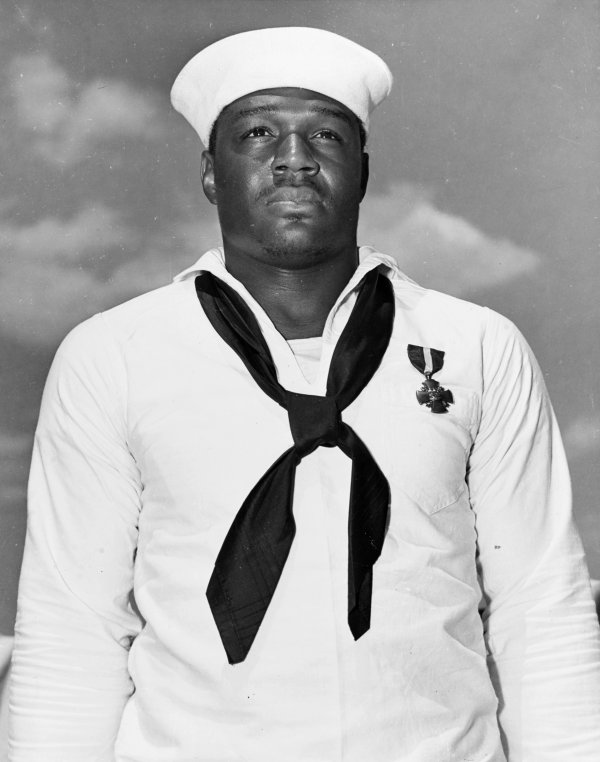 200117-N-NO101-150<br /> WASHINGTON (Jan. 17, 2020) In this file photo taken May 27, 1942, Mess Attendant 2nd Class Doris Miller stands at attention after being awarded the Navy Cross medal for for his actions aboard the battleship USS West Virginia (BB-48) during the Dec. 7, 1941 Japanese attack on Pearl Harbor. The medal was presented to Miller by Adm. Chester Nimitz aboard the aircraft carrier USS Enterprise (CV-6) during a ceremony in Pearl Harbor, Hawaii. (U.S. Navy photo/Released)