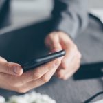 Aplikasi Kurban Digital 2026: Seorang pria urban sedang melihat layar ponsel pintar