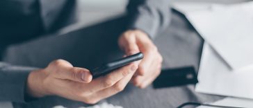 Aplikasi Kurban Digital 2026: Seorang pria urban sedang melihat layar ponsel pintar