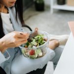 Seorang karyawan kantor menikmati camilan sore sehat di meja kerja saat jam istirahat [Ilustrasi Foto: Kaboompics via Pexels]