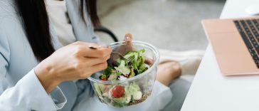 Seorang karyawan kantor menikmati camilan sore sehat di meja kerja saat jam istirahat [Ilustrasi Foto: Kaboompics via Pexels]