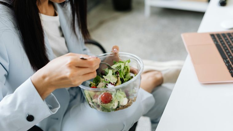 Seorang karyawan kantor menikmati camilan sore sehat di meja kerja saat jam istirahat [Ilustrasi Foto: Kaboompics via Pexels]