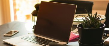 Ilustrasi ruang kerja minimalis modern anak muda produktif dengan laptop dan pencahayaan hangat estetik tahun 2026.