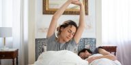 Gerakan peregangan tangan di atas kasur saat bangun tidur di pagi hari yang cerah