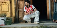 OOTD jersey bola: Seorang pria muda tampil modis mengenakan jersey vintage yang dipadukan dengan celana jeans longgar dan sepatu kets retro