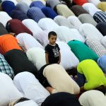 Panduan lebaran kurban 2026: Suasana umat Muslim sedang melaksanakan ibadah salat Idul Adha secara berjamaah di lapangan terbuka hijau