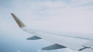 Pesawat terbang di angkasa sebagai ilustrasi tips berburu tiket pesawat murah