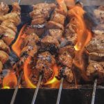 Olah Daging Kambing: Sajian hidangan sate daging kambing bumbu kecap tradisional yang menggugah selera yang sedang dibakar.