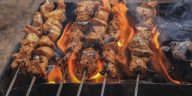 Olah Daging Kambing: Sajian hidangan sate daging kambing bumbu kecap tradisional yang menggugah selera yang sedang dibakar.
