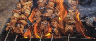 Olah Daging Kambing: Sajian hidangan sate daging kambing bumbu kecap tradisional yang menggugah selera yang sedang dibakar.