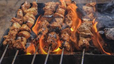 Olah Daging Kambing: Sajian hidangan sate daging kambing bumbu kecap tradisional yang menggugah selera yang sedang dibakar.