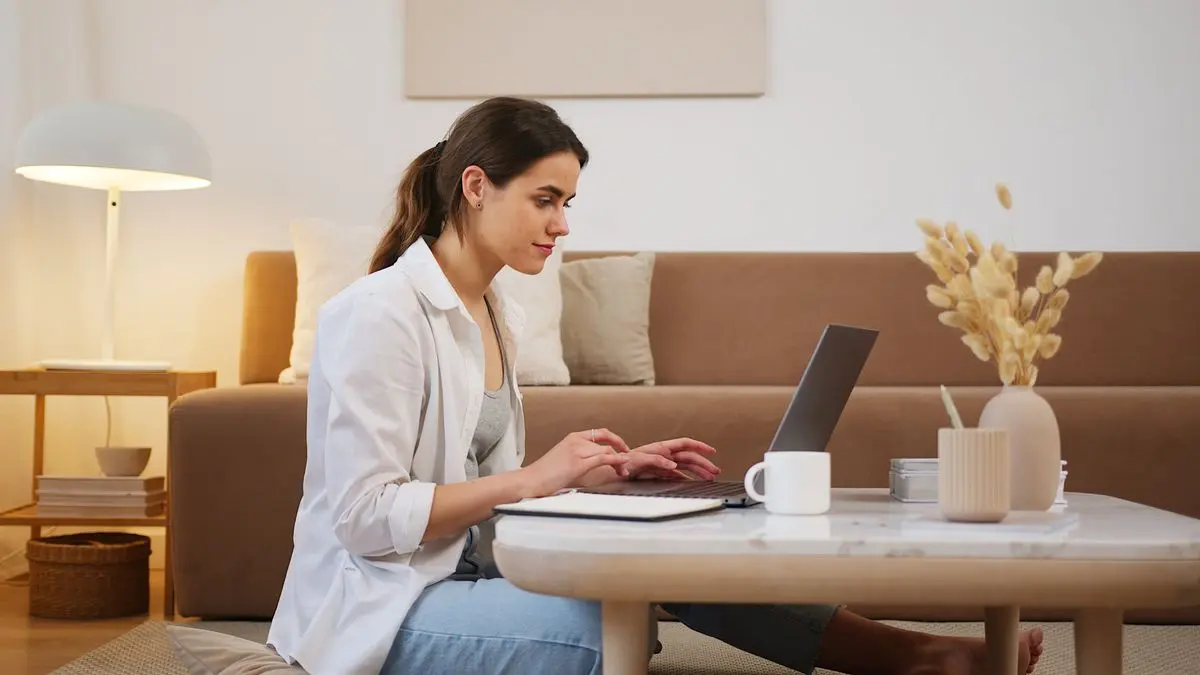 Productized Service AI : Ilustrasi seorang wanita sedang fokus menatap ayar laptop modern