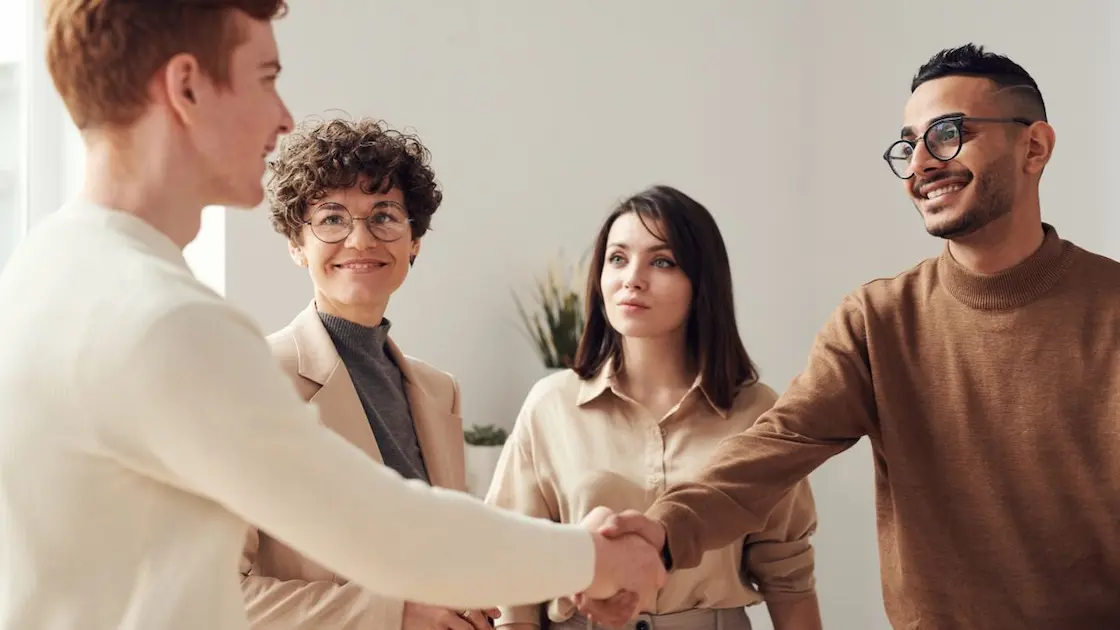 Soft skill dunia kerja: Sejumlah profesional muda yang sedang berdiskusi dengan rekan kerja di kantor modern