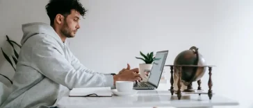 Meja kerja di rumah dengan laptop tertutup menandakan batas waktu kerja WFH
