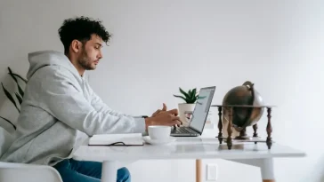 Meja kerja di rumah dengan laptop tertutup menandakan batas waktu kerja WFH