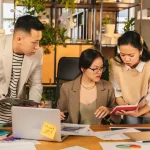 Ilustrasi profesional mengelola beban kognitif kerja tim lintas generasi di ruang kantor modern