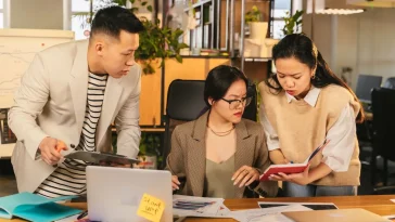 Ilustrasi profesional mengelola beban kognitif kerja tim lintas generasi di ruang kantor modern