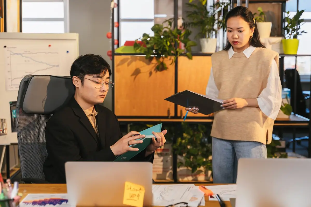 Seseorang memeriksa format laporan kerja berbasis poin di layar komputer kantor