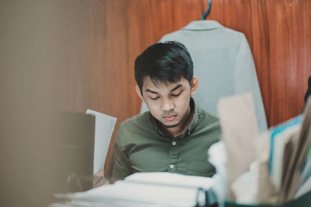 Seseorang mencatat langkah kecil untuk memecah proyek besar di buku catatan