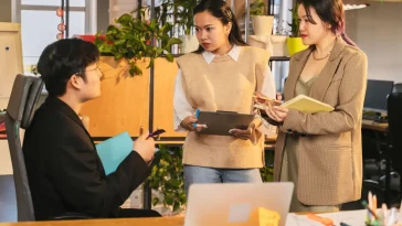 Ilustrasi profesional membaca dinamika kuasa rapat dan aliran pengaruh di ruang meeting kantor