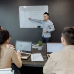 Seseorang membangun aliansi kerja dan pengaruh profesional secara kolaboratif di kantor