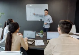 Seseorang membangun aliansi kerja dan pengaruh profesional secara kolaboratif di kantor